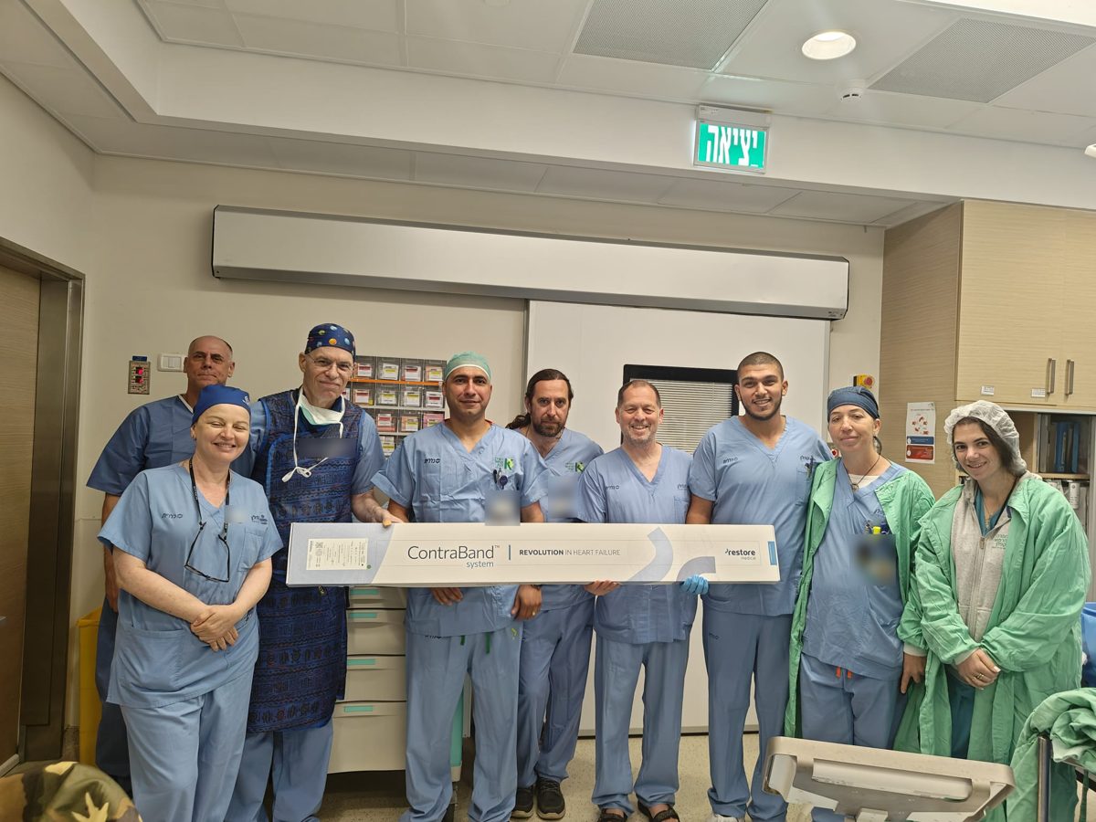 Clinical team in a catheterization lab holding the ContraBand system box