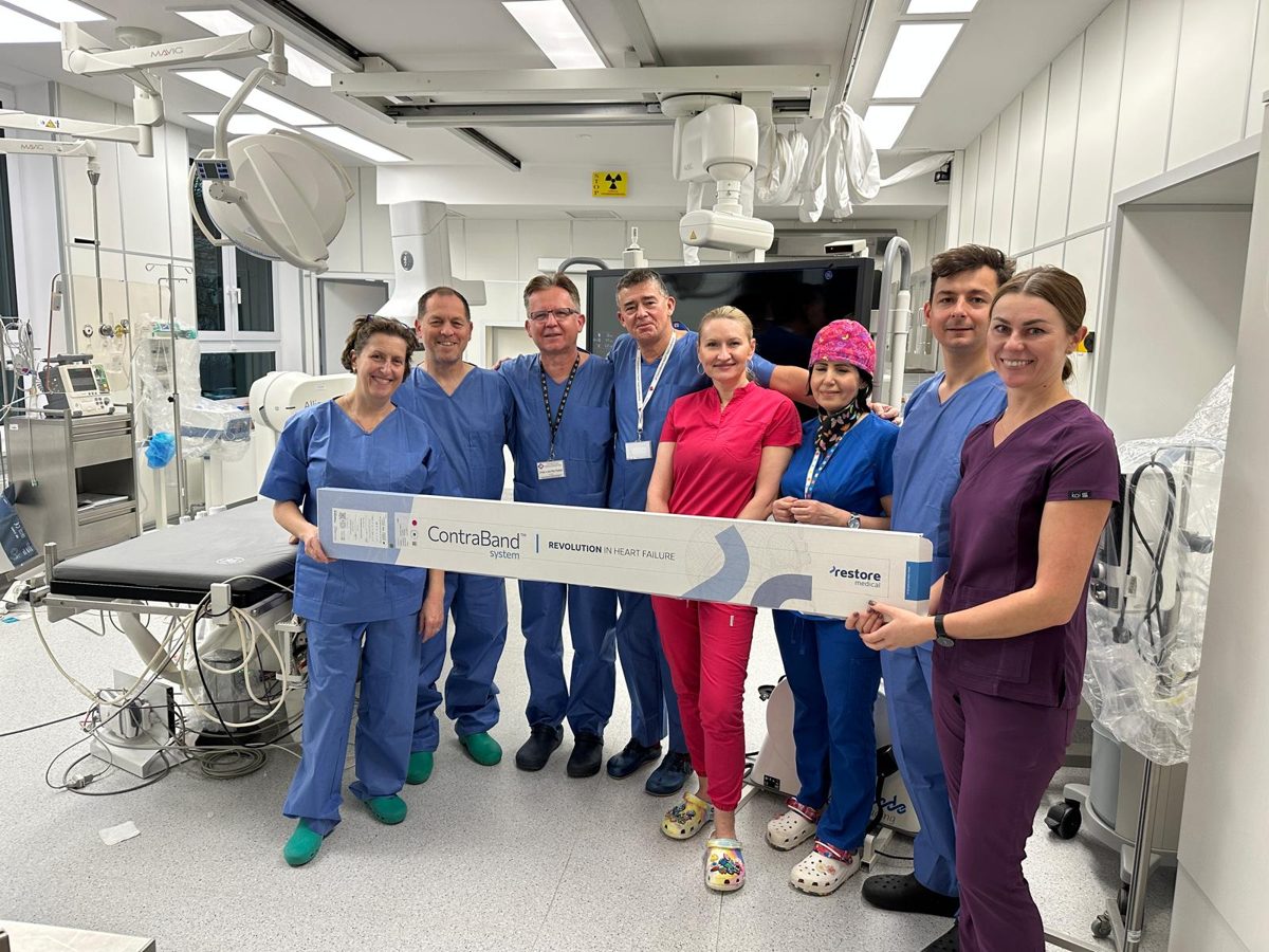 Clinical team in a catheterization lab holding the ContraBand system box